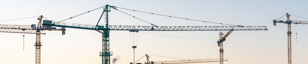 Construction site, cranes and multi storey unfinished buildings