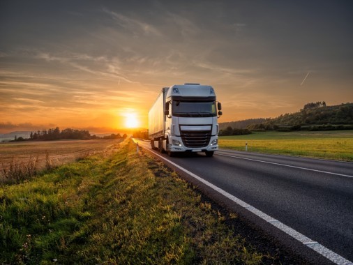 White truck driving on the asphalt road