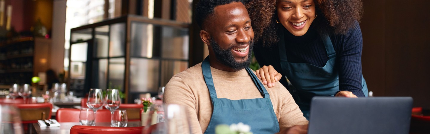 Small business owners using laptop in restaurant