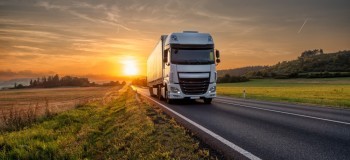 White truck driving on the asphalt road